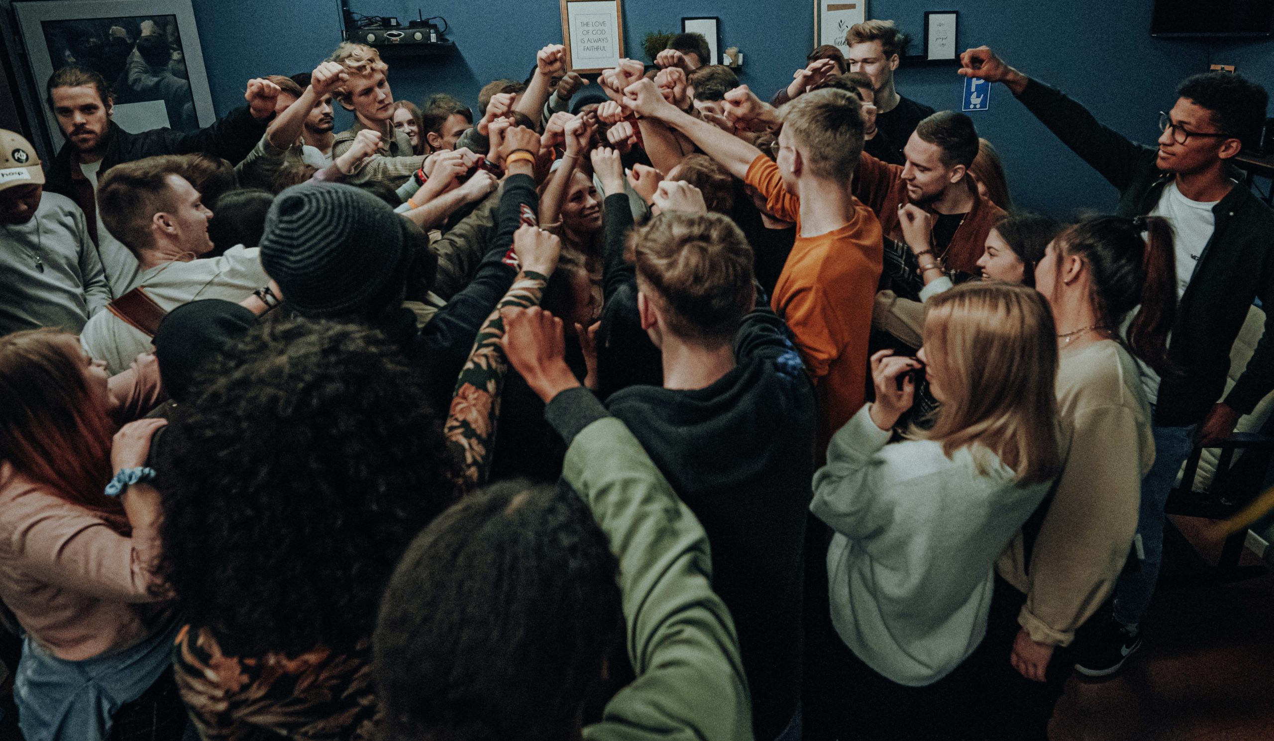 Group of young teenagers gathering together with there fists in the air